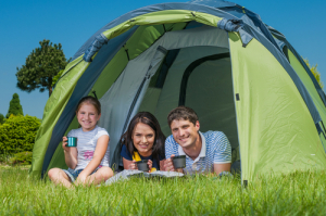 Families resting on the grass and camping with tent