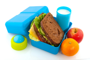 Healthy filled lunch box with whole meal bread vegetables and milk