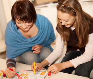 Mother and her daughter drawing together.